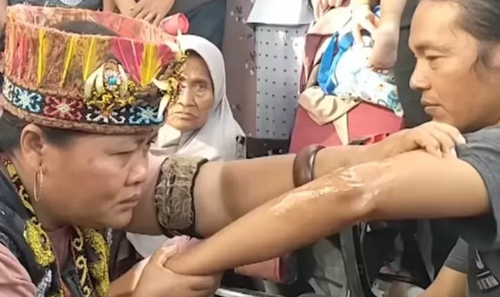 Ida Dayak saat mengobati pasiennya. (Ist)