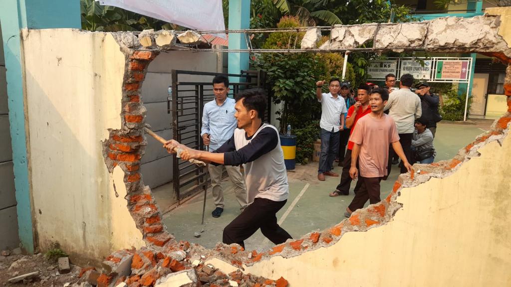 Pekerja saat menggempur tembok lama didepan SD Negeri Lengkong Karya yang akan digunakan sebagai akses baru sekolah tersebut.(dra)