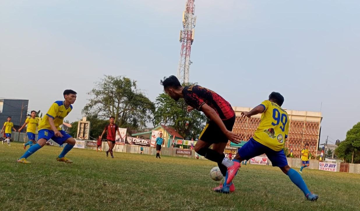 Gelandang H Saemin FC, Hasnul (kostum merah hitam) berduel dengan pemain Putra Peninggilan.(Foto: red/tangselpos.id).