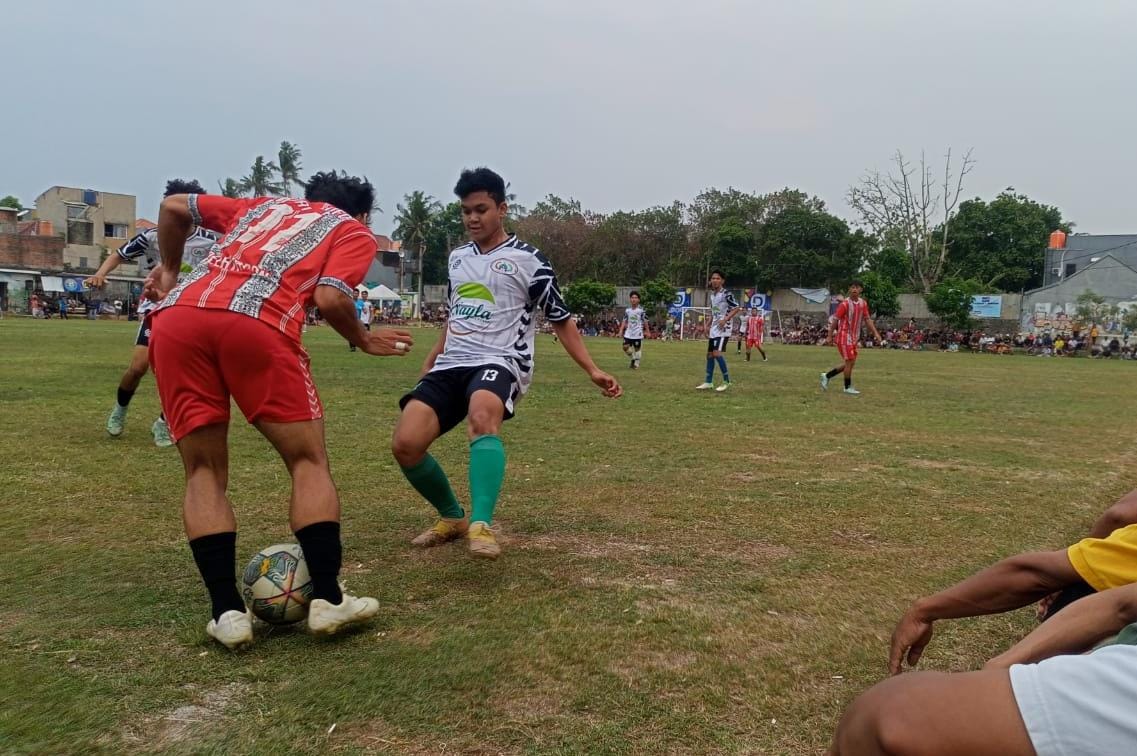 Pemain muda Nayla A FC, Dinko (hitam putih) berusaha merebut bola dari kaki pemain Rajawali FC.(Foto: Red/tangselpos.id).