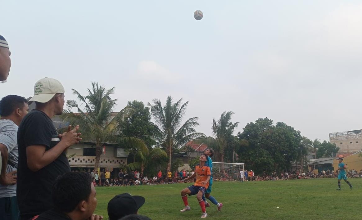 Pemain Dejan FC, Wawan (kostum oranye) berduel dengan pemain Pinggiran FC.(Foto: Red/tangselpos.id).