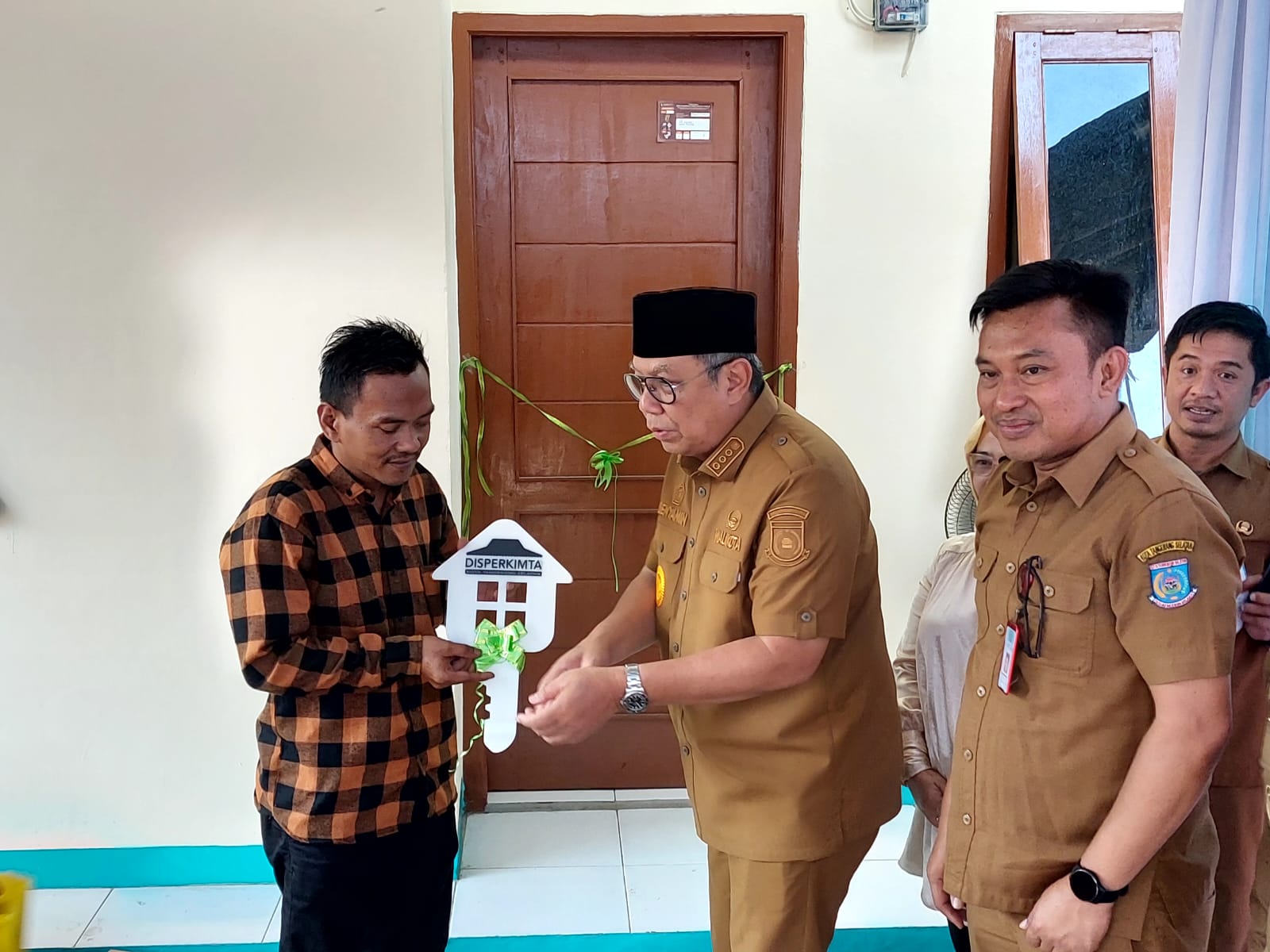 Penyerahan simbolis kunci rumah oleh Wali Kota Tangsel, Benyamin Davnie kepada pemerima manfaat perbaikan RUTLH di wilayah Rawa Buntu, Serpong. Foto : Ist