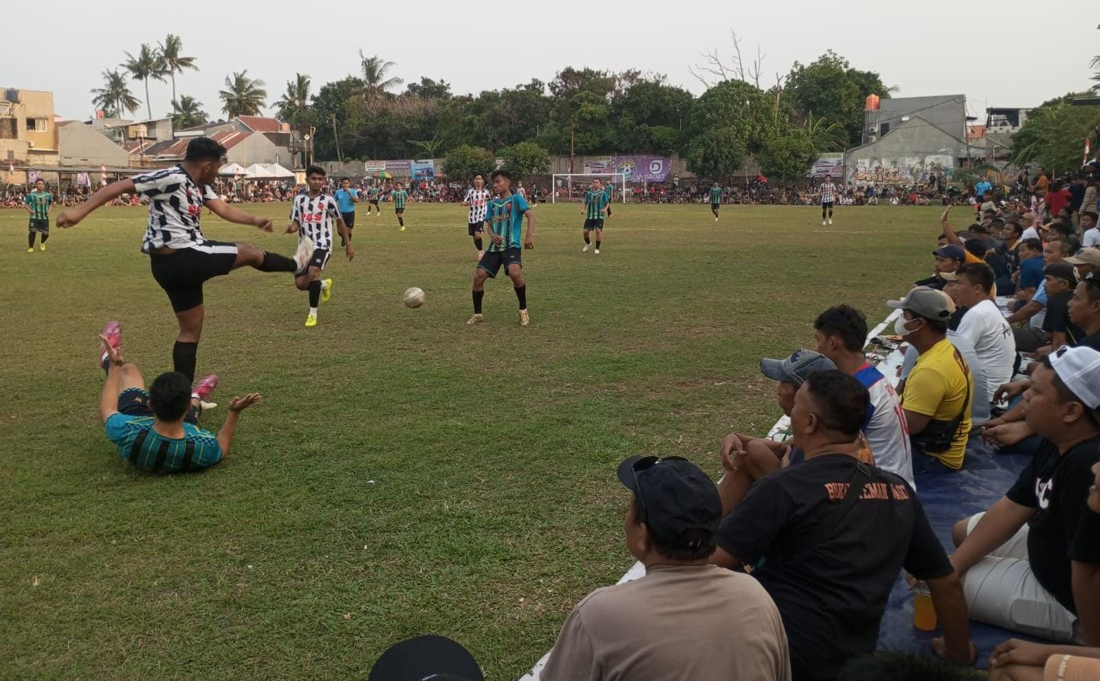 Bek Aceh Seranto FC sapu bersih bola di saat pemain Soneta FC terjatuh. (red/tangselpos.id).