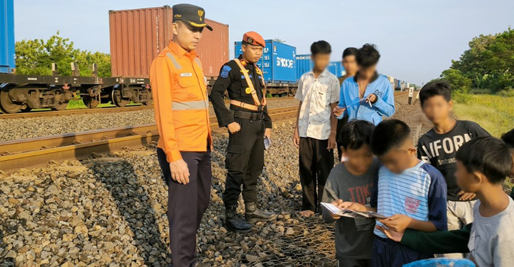 Petugas KAI sedang memberikan edukasi kepada warga di daerah Stasiun Karawang. Foto : Ist