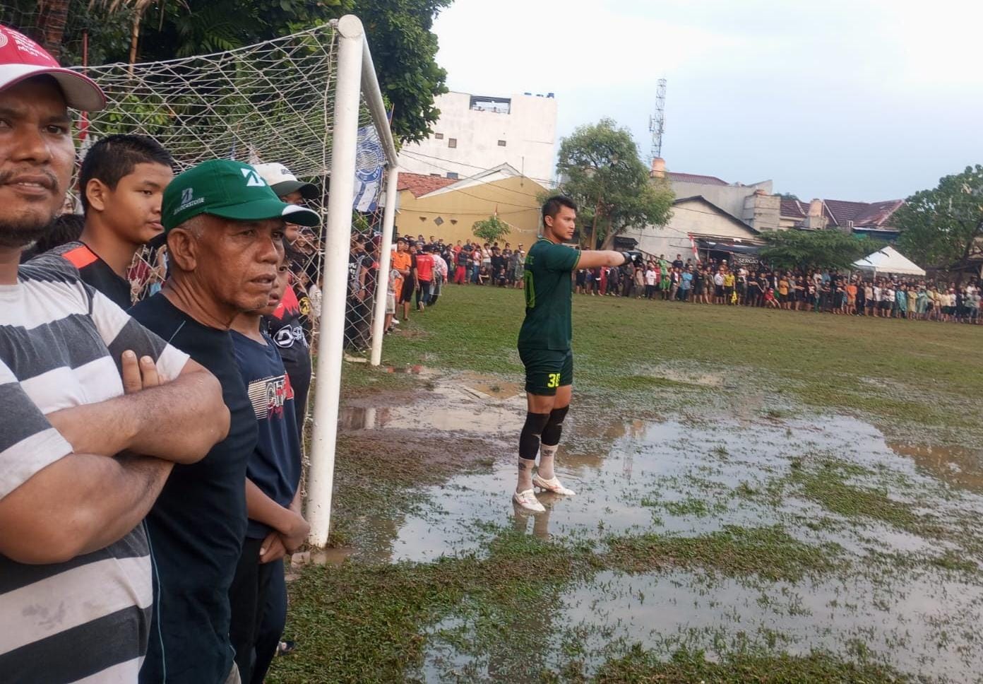 Kiper HBB Boy, Shahar Ginanjar berdiri di genangan air akibat hujan deras yang mengguyur. Meski hujan, ribuan penonton tetap antusias. (red/tangselpos.id)