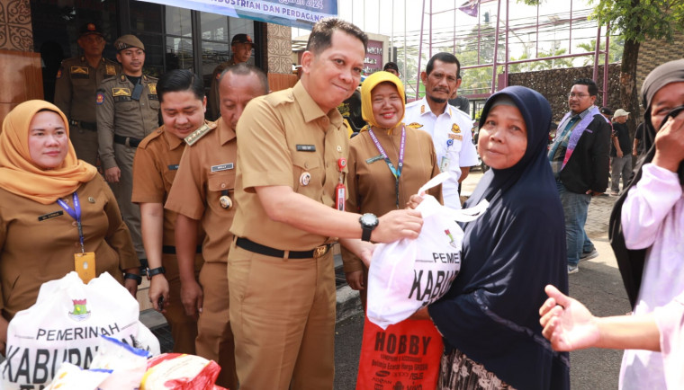 Penjabat (Pj) Bupati Tangerang, Andi Ony, secara simbolis menyerahkan paket Gerakan Pangan Murah (GPM) yang dijual kepada warga di Halaman Kantor Kecamatan Balaraja, Selasa (5/11).