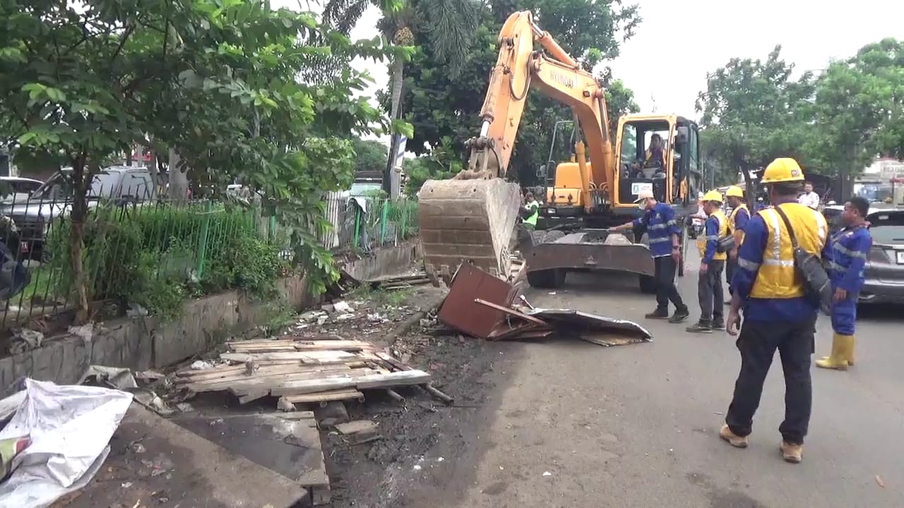 Sebuah alat berat dikerahkan untuk membantu petugas gabungan membongkar bangunan semi permanen yang menjadi bagian dari lapak PKL. Lapak mereka ini berada di atas saluran air sepanjang Jalan Raden Fatah atau kawasan Pasar Lembang, Kecamatan Ciledug, Senin (23/12).