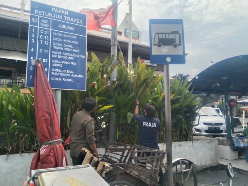 Petugas Ketentraman dan Ketertiban Umum (Trantibum) Kecamatan Ciledug, Kota Tangerang tengah melakukan penertiban terhadap atribut Organisasi Masyarakat (Ormas) yang terpasang di persimpangan Jalan Hasyim Ashari.