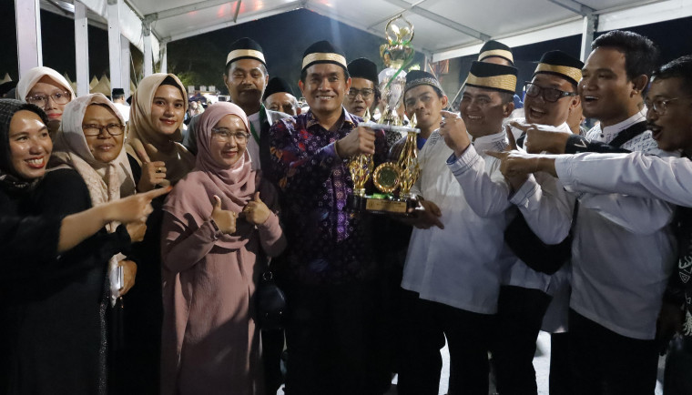 Camat Mekar Baru, Aan Ansori, tampak memegang Piala Bergilir Musabaqoh Tilawatil Qur’an (MTQ)  ke-55 tingkat Kabupaten Tangerang, usai kecamatannya berhasil keluar sebagai juara umum.