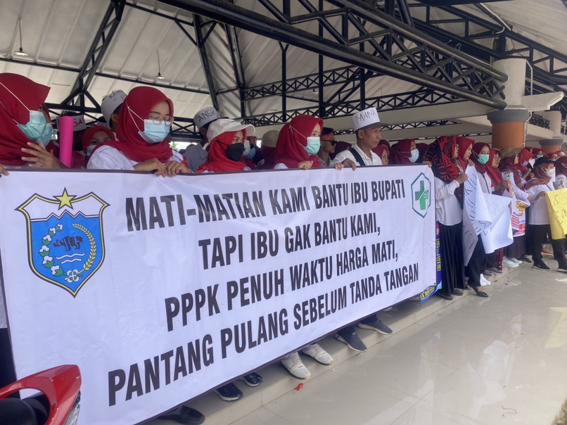 Massa unjuk rasa sedang membentangkan spanduk kecaman kepada Bupati Pandeglang di Pancaniti Alun-alun Pandeglang, Kamis (16/1).(pal)