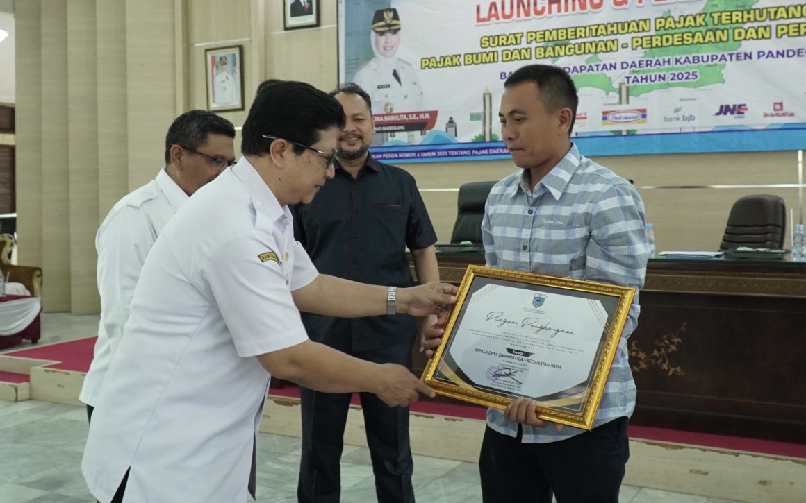 Kepala Bapenda Pandeglang Ramadani sedang memberikan penghargaan kepada Kepala Desa yang lunas wajak di Aula Pendopo, Rabu (15/1).