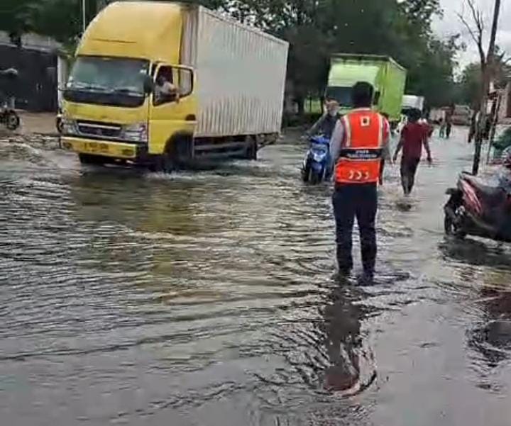 Petugas Dinas Perhubungan (Dishub) Kota Tangerang tampak sedang mengatur lalu lintas di jalan utama yang terdampak genangan. Hal ini untuk memastikan tidak ada kendaraan yang mogok akibat banjir ataupun nekat menerobos banjir sehingga membahayakan pengendara.