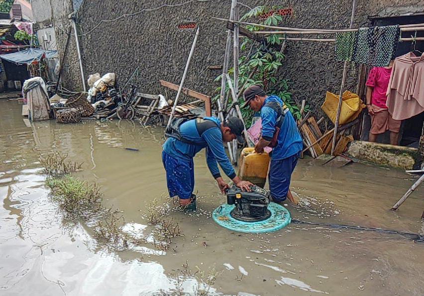 Petugas Dinas Pekerjaan Umum dan Penataan Ruang (PUPR) Kota Tangerang, tengah memasang pompa air guna mengatasi banjir yang terjadi di lingkungan pemukiman warga di RT 03, RW 02, Kedaung Baru, Neglasari, Kota Tangerang.