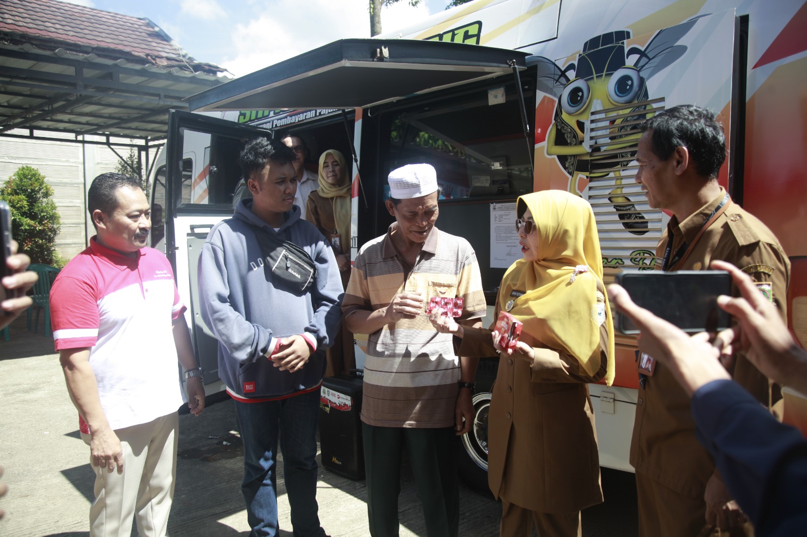 Tim Kesehatan Siaga Di Samsat Pandeglang Bupati Pandeglang Raden Dewi Setiani bersama Kepala UPT Samsat Pandeglang Epy Shafiullah sedang memberikan suplemen kepada wajib pajak di Samsat Pandeglang, Selasa (22/4)