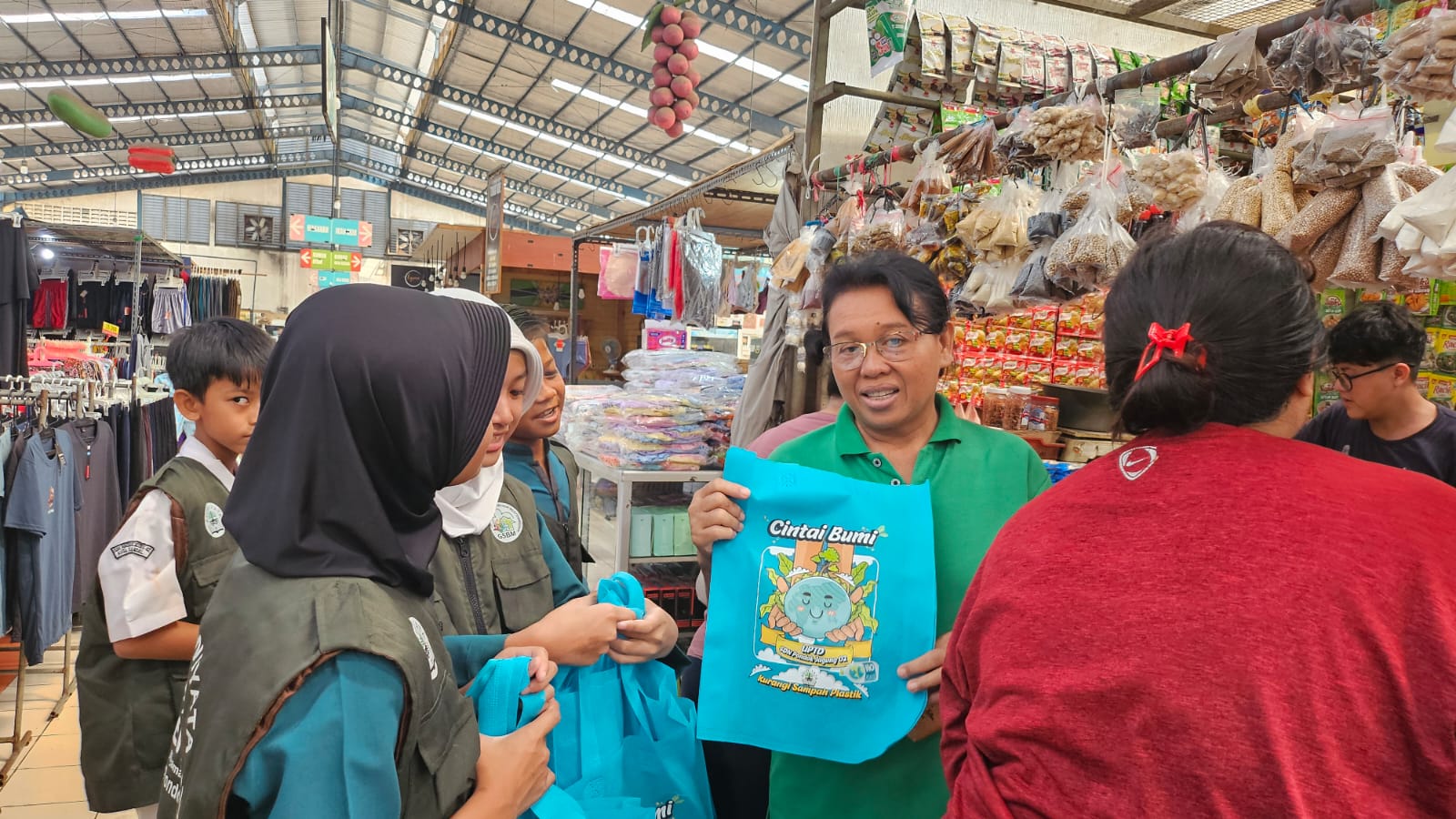 Siswa SD Bagikan Tas Belanja Ramah Lingkungan Ke Pengunjung Pasar Kader Adiwiyata SDN Pondok Jagung 02 saat bagi-bagi tas jinjing ke pengunjung pasar di wilayah Serpong Utara, Senin (5/5)