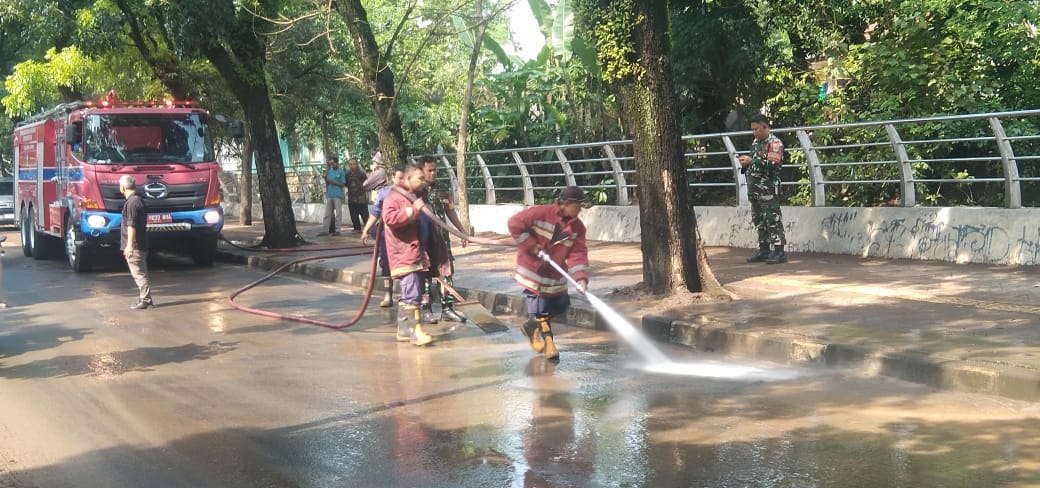 Usai Surut, Damkar Tangsel Semprot Lumpur di Jalanan yang Terendam Banjir Foto : Ist