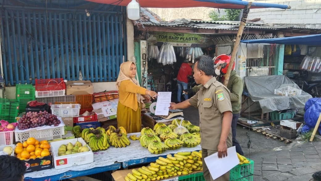 Petugas Tramtib Kecamatan Tangerang saat membagikan surat edaran kepada PKL.