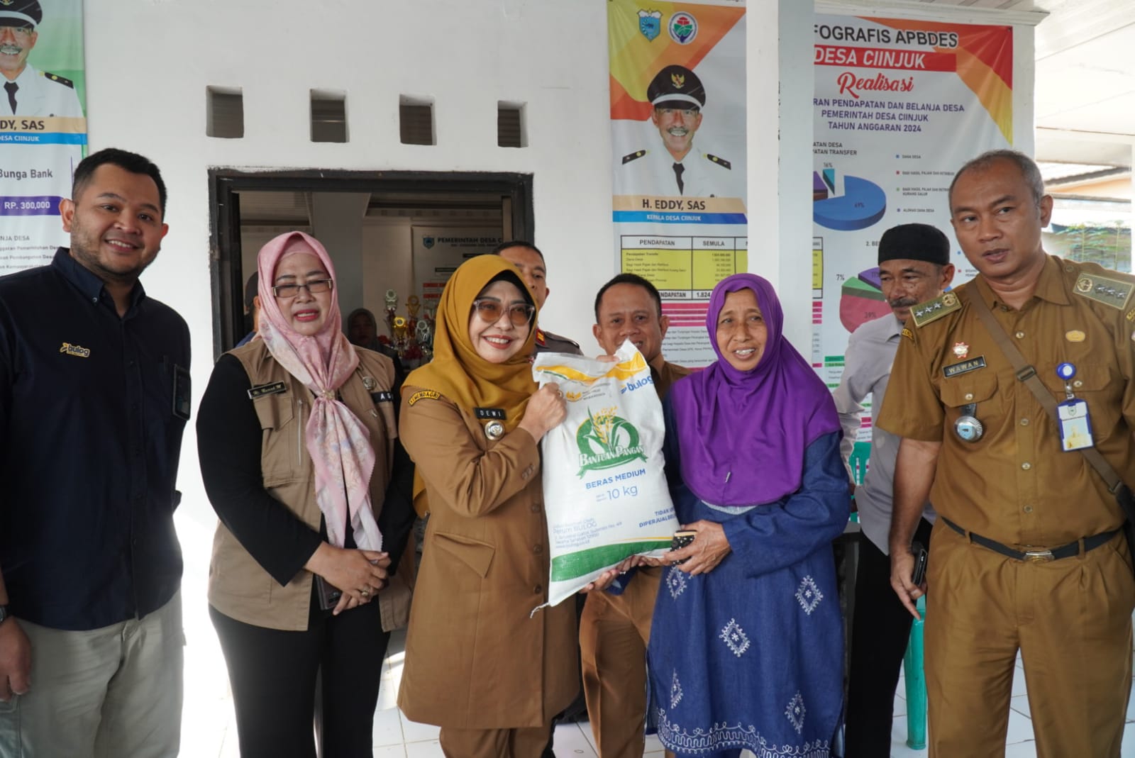 88 Ribu Warga Pandeglang Diguyur Bantuan Beras Bupati Pandeglang Raden Dewi Setiani didampingi jajarannya sedang menyerahkan bantuan beras kepada penerima di Aula Desa Ciinjuk, Kecamatan Cadasari, Kabupaten Pandeglang, Selasa (22/7).