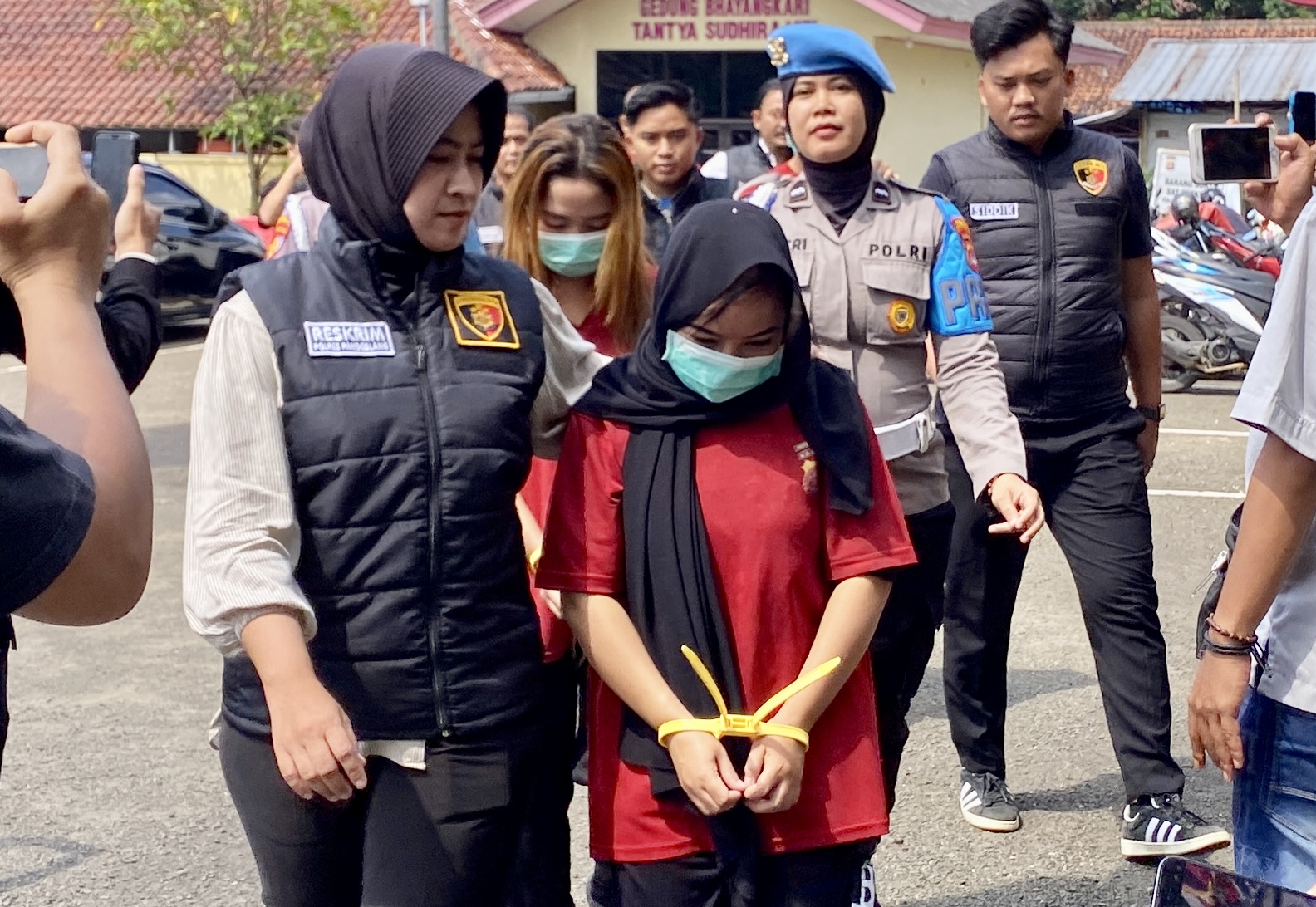 Anak Dibawah Umur Dijual Untuk Jadi PSK Jajaran Satreskrim Polres Pandeglang sedang menggiring para tersangka kasus TPPO dengan tangan terikat kabel tis dan menggunakan baju tahanan, saat hendak melakukan ekspose di halaman Mapolres Pandeglang, Rabu (30/7).