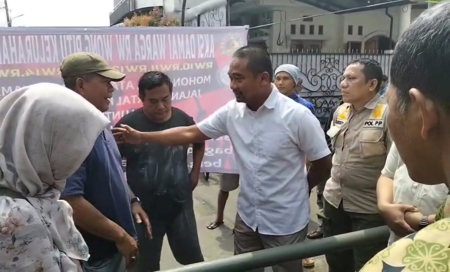 Warga Tolak Bongkar Portal Yang Tutup Akses Ke SMAN 3 Tangsel Kepala Bidang Penegakan Hukum dan Perundang-Undangan Satpol PP Tangsel, Muksin Alfachry saat dihadapkan oleh warga Benda Baru, Kamis (3/7)