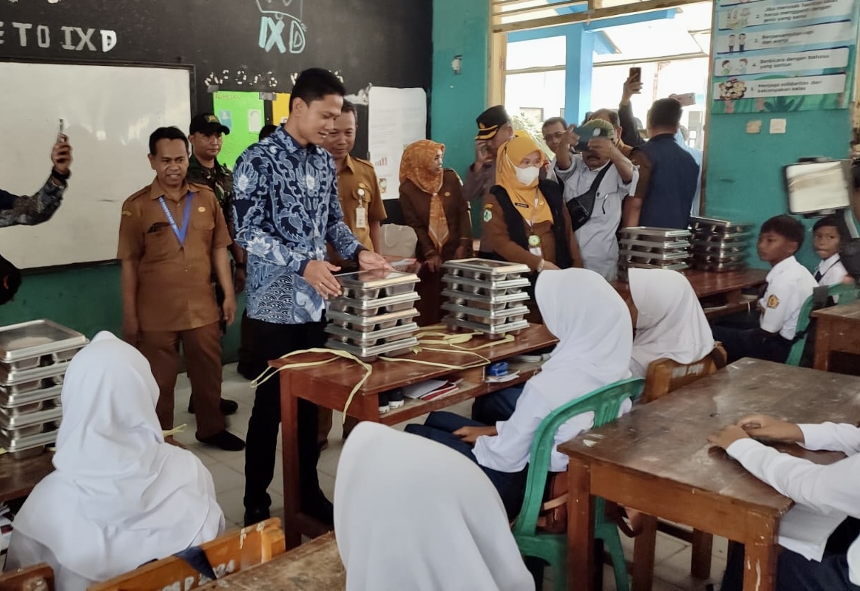 Wakil Bupati Pandeglang, Iing Andri Supriadi sedang membangikan MBG kepada para pelajar di SMPN 1 Labuan, pada saat acara launching, Senin (25/8)