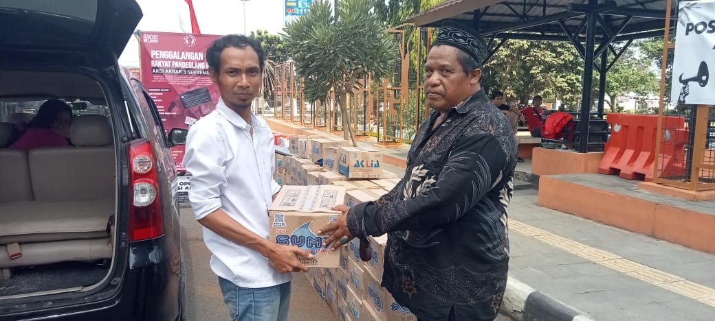 Pernyataan Bupati Dewi Soal Sampah Dinilai Bukan Harapan Rakyat Juru bicara GRPM Rohmat, sedang menerima donasi berupa air mineral dari salah seorang masyarakat yang peduli terhadap gerakan rakyat yang menolak kerja sama sampah dengan daerah lain, di Jalan Pandeglang-Labuan, tepat di depan Pendopo Bupati Pandeglang, beberapa waktu lalu.