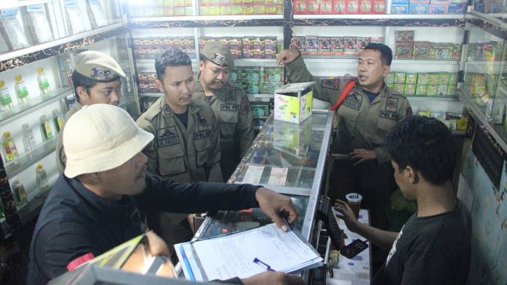 Petugas gabungan dari Satpol PP Kota Tangerang, TNI dan Polri melakukan operasi peredaran miras di sejumlah warung kelontong di Kota Tangerang, Kamis (18/9) dinihari.
