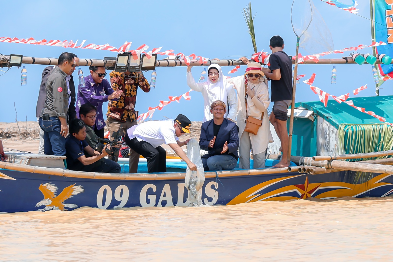 Gubernur Banten Andra Soni didampingi Ketua TP PKK Banten Tinawati Andra Soni, dan jajaran lainnya, sedang menaburkan benih ikan di Muara tak jauh dengan lokasi acara Festival Karang Kabua 2025, di Kecamatan Bayah, Kabupaten Lebak, Minggu (12/10).