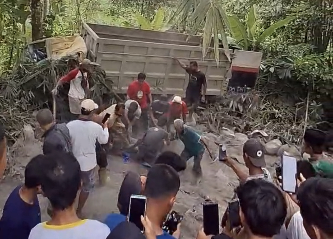 Truk Terguling, Dua Orang Tewas Tertimbun Semen Warga bersama para pihak lainnya sedang melakukan evakuasi terhadap korban yang tertimbun tumpukan semen di Tanjakan Sampang Jaha, Desa Gunungbatu, Kecamatan Munjul, Kabupaten Pandeglang, Minggu (19/10).