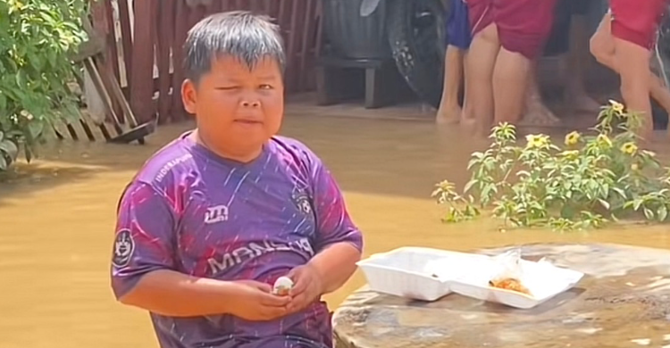 Seorang bocah sedang makan menu MBG di tengah suasana banjir di Sumbar. Foto : Ist