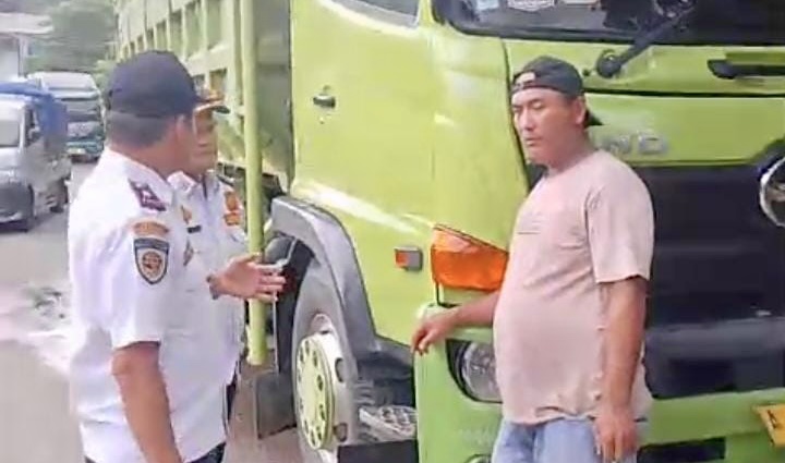 Petugas Dishub Pandeglang, sedang menghentikan truk bertonase besar yang melintas di luar jam operasional.