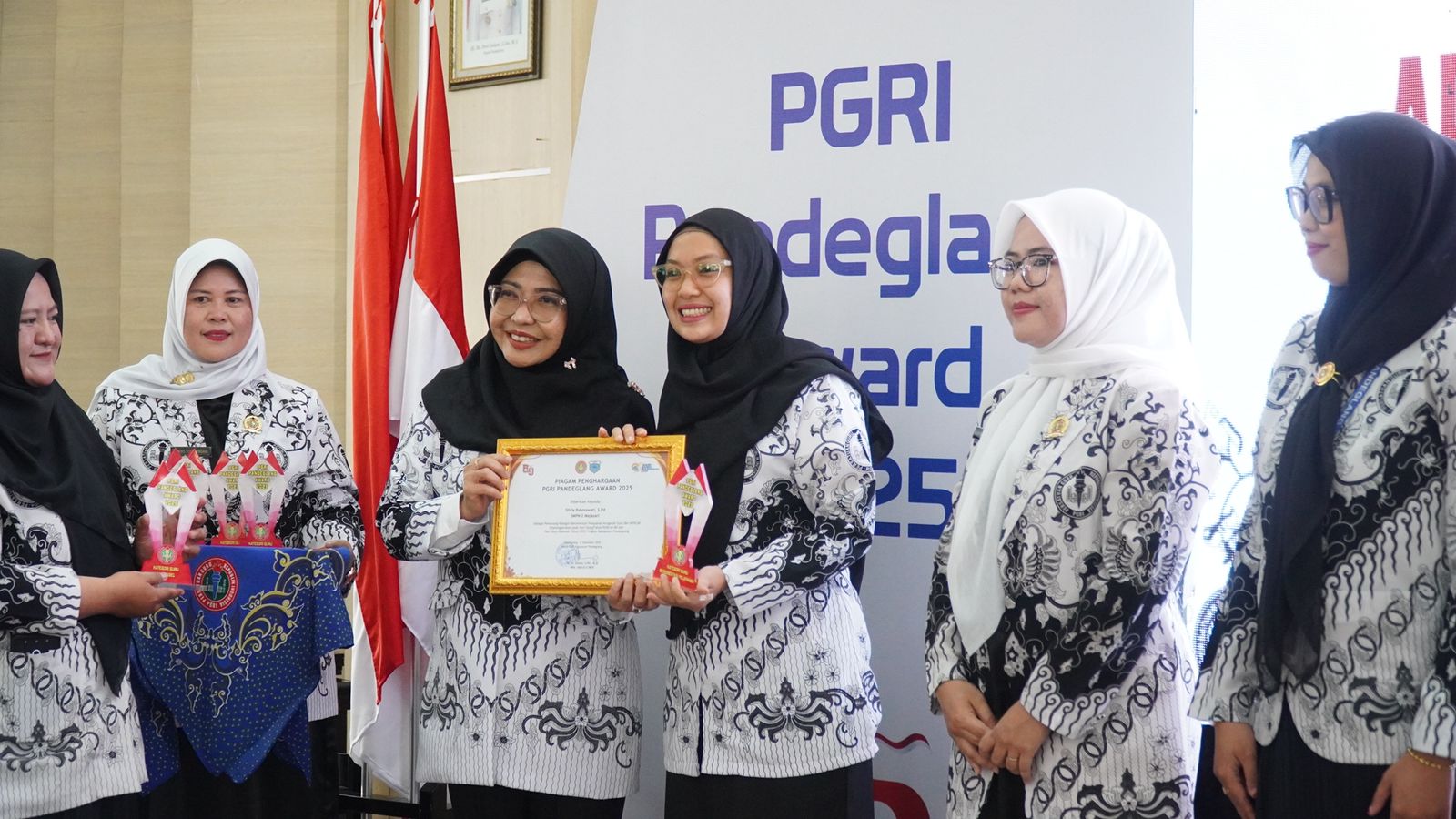 Bupati Raden Dewi Setiani menyerahkan piagam penghargaan kepada guru dalam acara HUT ke-80 PGRI dan HGN di Gedung Negara Pendopo Pandeglang, Jumat (12/12/2025).(Istimewa)