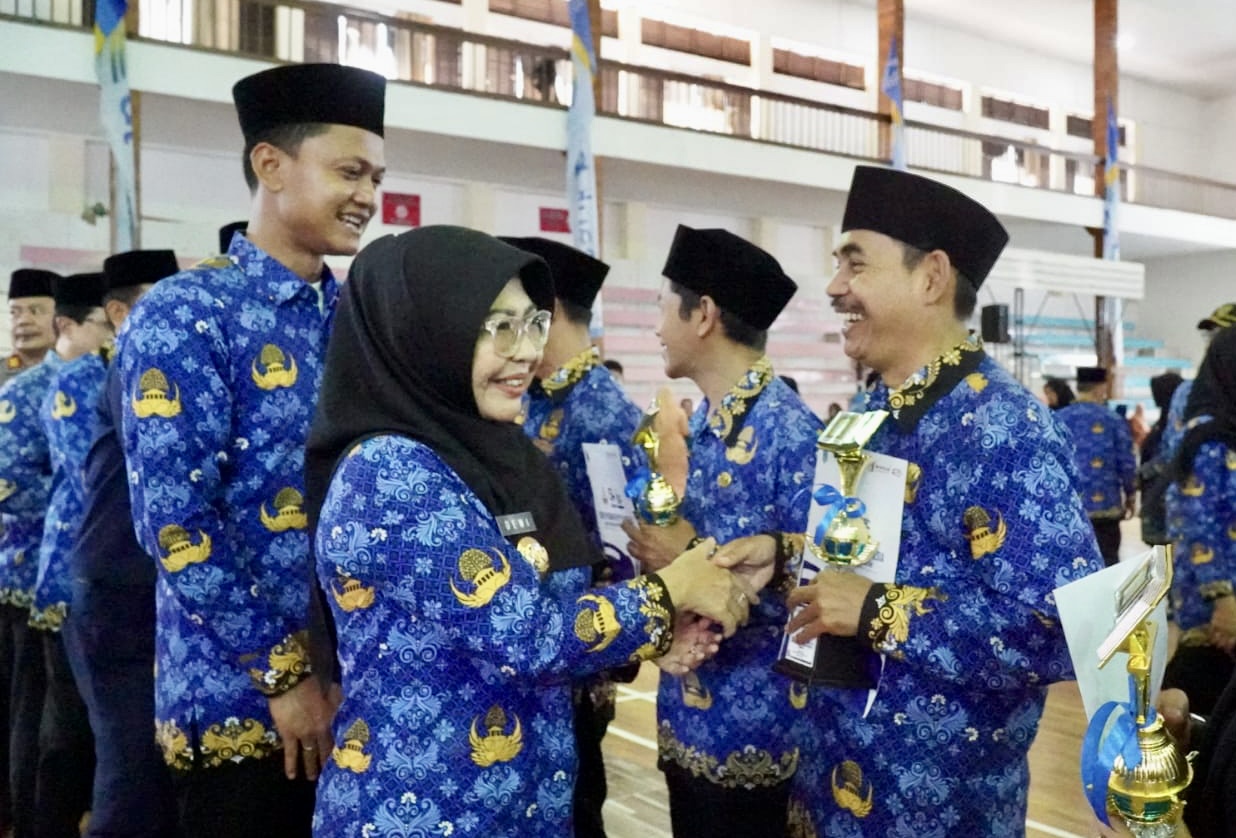 Tersenyum sumringah, Bupati-Wabup Pandeglang Dewi-Iing sedang memberikan apresiasi kepada para ASN yang sudah menorehkan prestasi di acara HUT Korpri ke 54 tingkat Pandeglang, di Gedung Graha Pancasila, Senin (1/12).