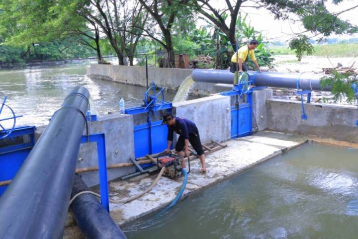 Petugas tengah mengoperasikan mesin pompa air guna mengantisipasi banjir.