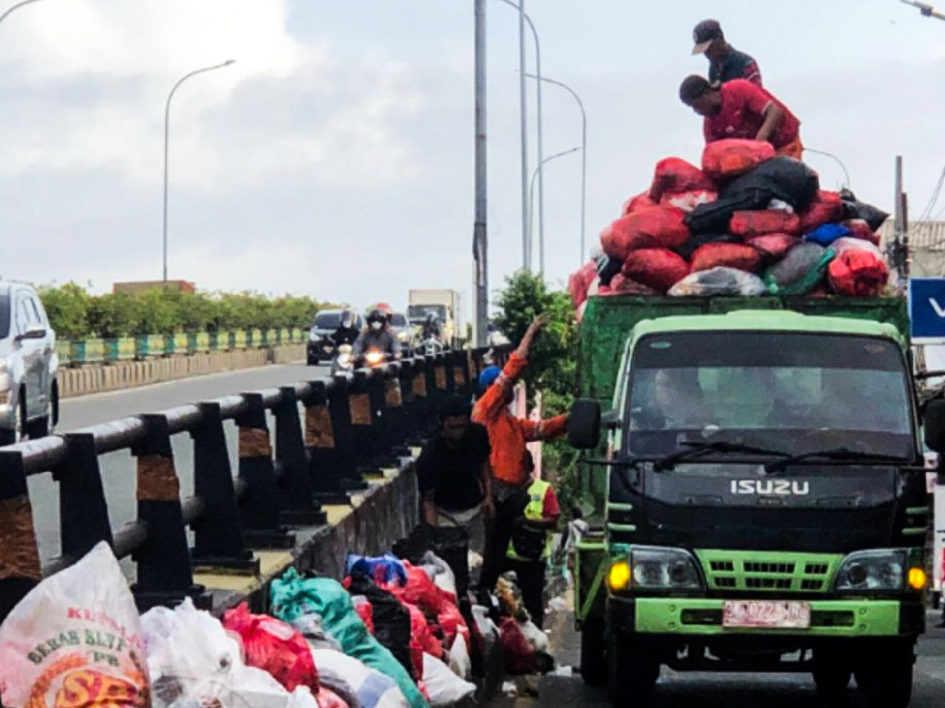 Petugas kebersihan mengevakuasi tumpukan sampah di Fly Over Ciputat. (Dok. Humas Pemkot Tangsel)