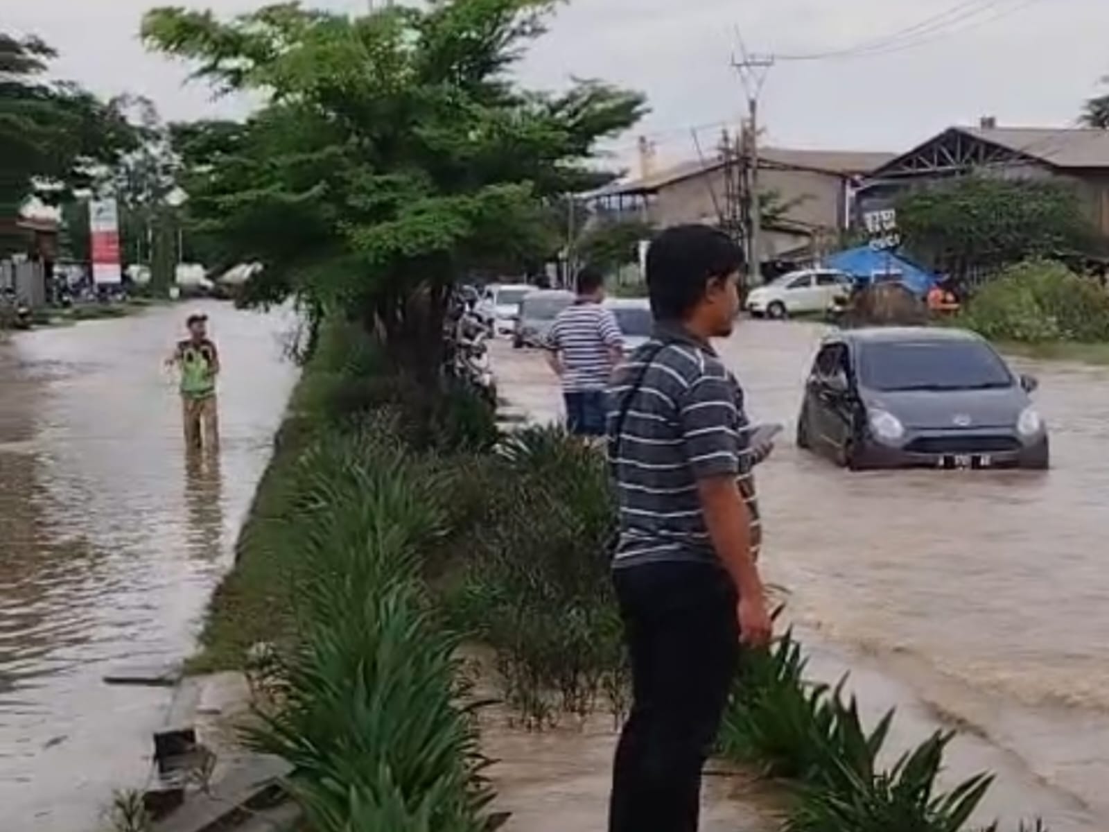 Kendaraan melintas di genangan banjir yang merendam Jalan Lingkar Selatan Cilegon, akses utama menuju kawasan wisata Anyer, Jumat (2/1/2025). (Ist)
