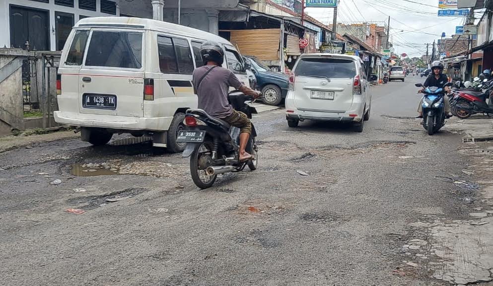 HATI-HATI. Para pengendara terutama roda dua terlihat sangat hati-hati saat melintas di Jalan Ciherang-Pandeglang, tepatnya di kondisi yang sangat rusak parah, Senin (5/1).