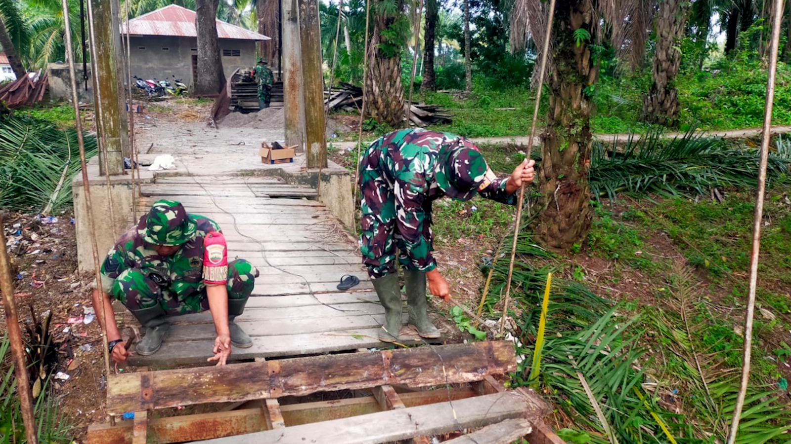 Anggota TNI sedang memperbaiki jalan rusak. Foto : Ist