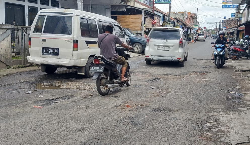 HATI-HATI. Para pengendara terutama roda dua terlihat sangat hati-hati saat melintas di Jalan Ciherang-Pandeglang, tepatnya di kondisi yang sangat rusak parah, Senin (5/1).
