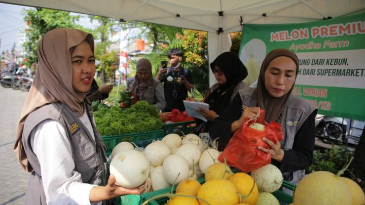 Anggota Kelompok Wanita Tani (KWT) Kota Tangerang menjajaki melon hidroponik kepada para pembeli, di kegiatan Gampang Sembako di tingkat kelurahan.