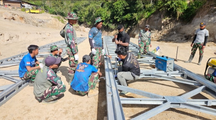 Anggota TNI dan Kementerian PU sedang merakit kerangka jembatan. Foto : Tim Media Presiden