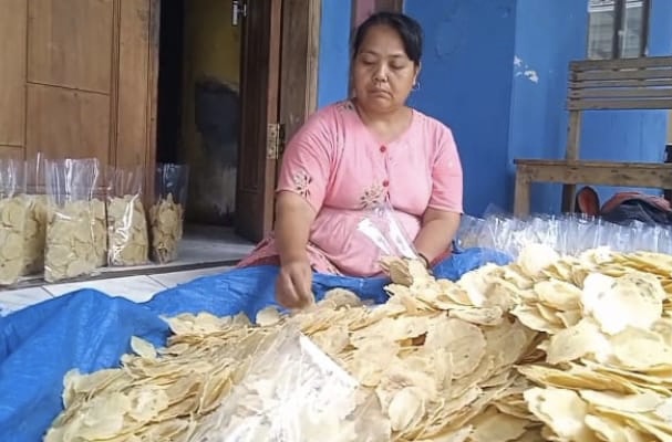 Salah seorang pengrajin emping melinjo di Desa Sindangsari, Kecamatan Warunggunung, Kabupaten Lebak, sedang mengemas emping melinjo ke dalam plastik. Kamis (5/2).