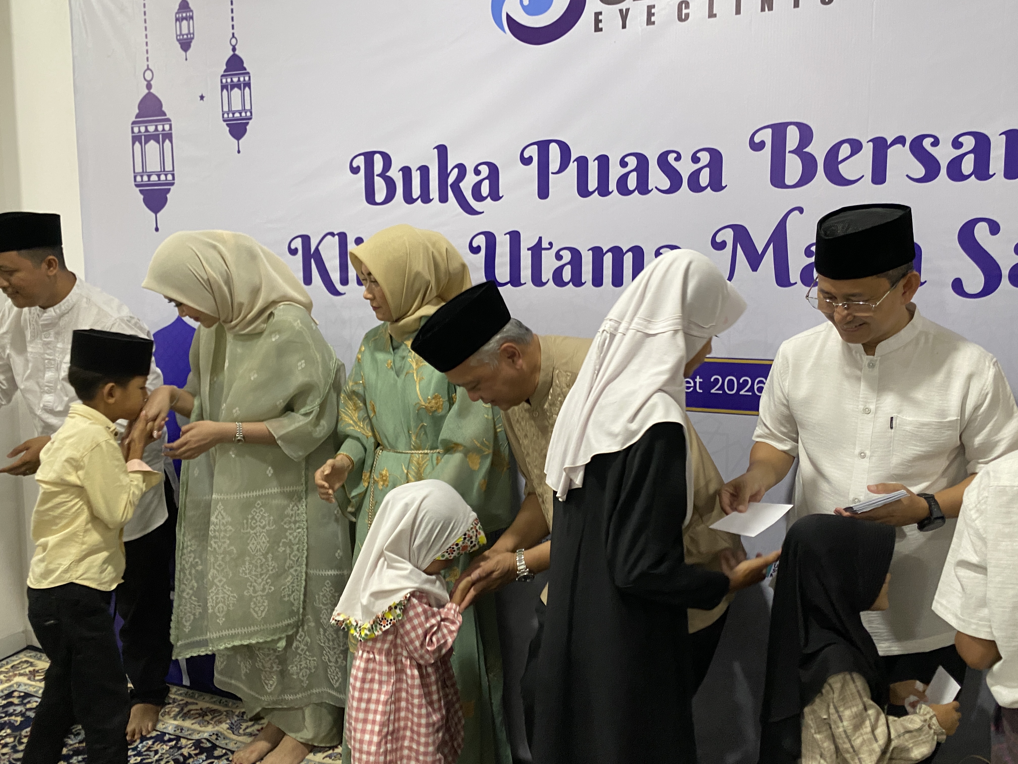 MENYANTUNI. Pihak Klinik Utama Mata Saruni sedang menyantuni dan menyalami anak-anak yatim, saat acara buka bersama di Kantor Klinik Utama Mata Saruni, Rabu (11/3).