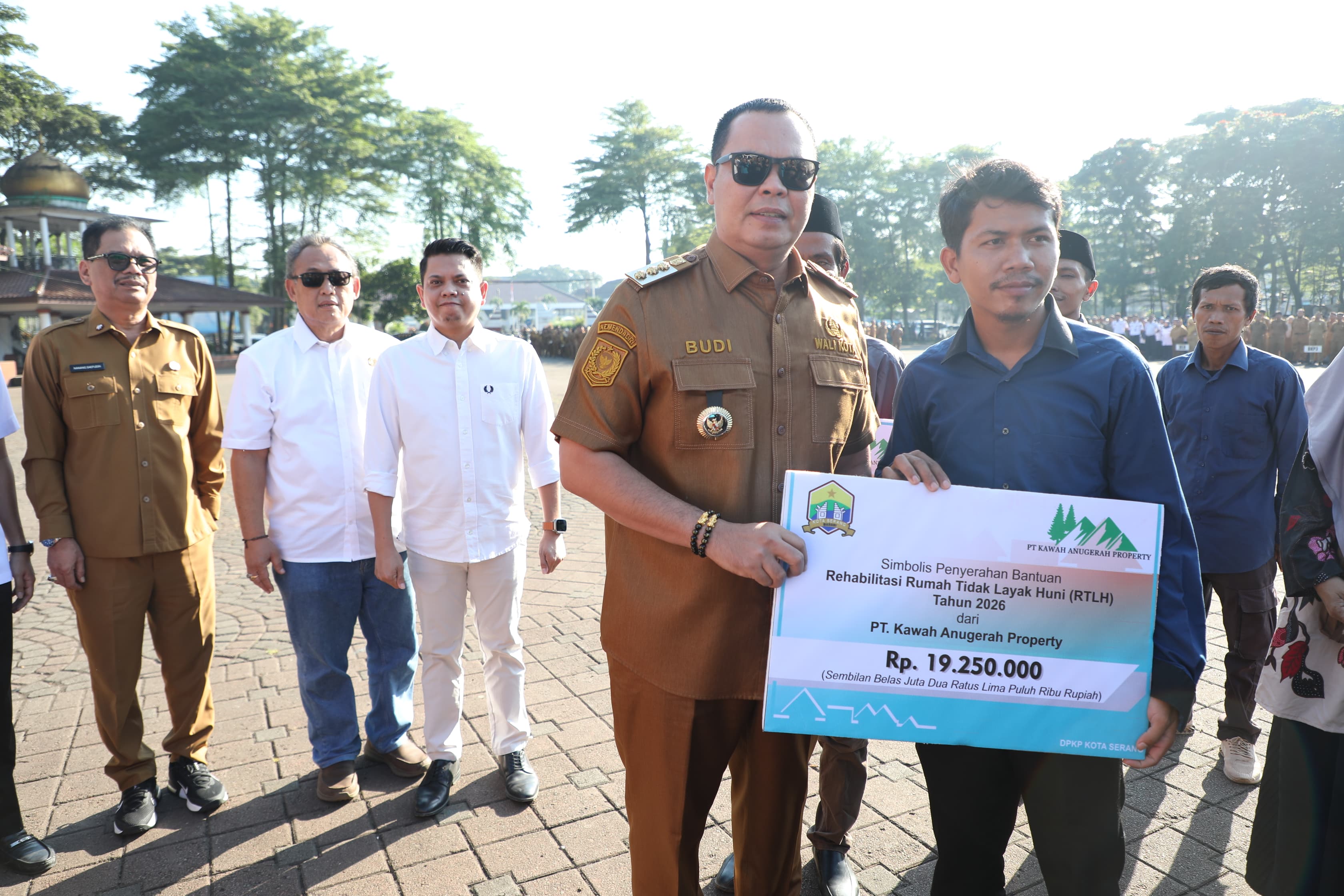 Wali Kota Serang, Budi Rustandi, menyerahkan bantuan program RTLH kepada warga dalam apel pagi di Alun-alun Barat Kota Serang, Senin (12/4/2026).(Istimewa)