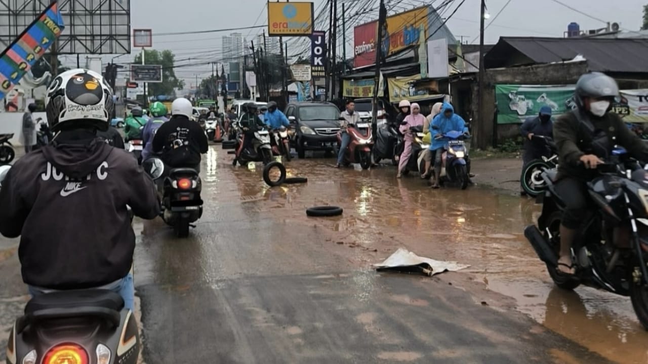 Kondisi jalan berlumpur terlihat di Jalan Raya Legok, tepat di depan gerbang Dasana Indah, Selasa (pagi). Lumpur akibat sisa hujan membuat permukaan jalan licin dan berpotensi membahayakan pengendara. Foto : Emir MG