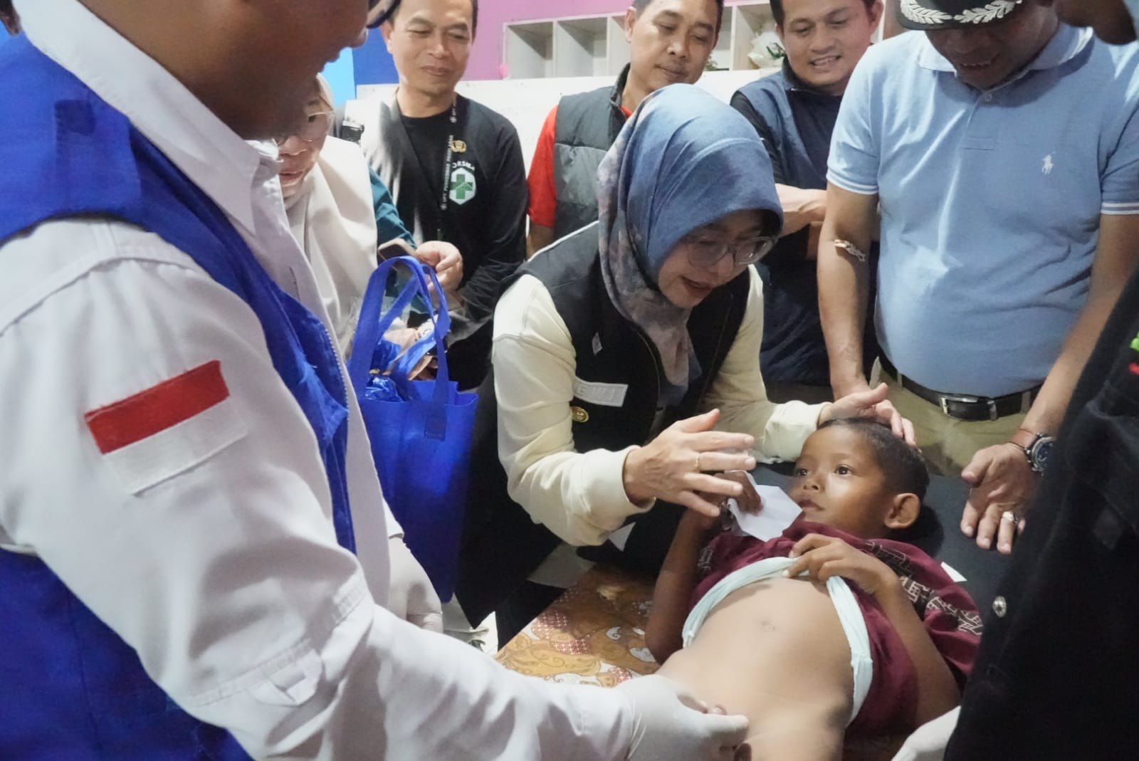 Bupati Pandeglang, Raden Dewi Setiani mendampingi anak yang tengah dikhitan dalam acara bakti sosial di Kecamatan Labuan, Selasa (14/4/2026).(Istimewa)