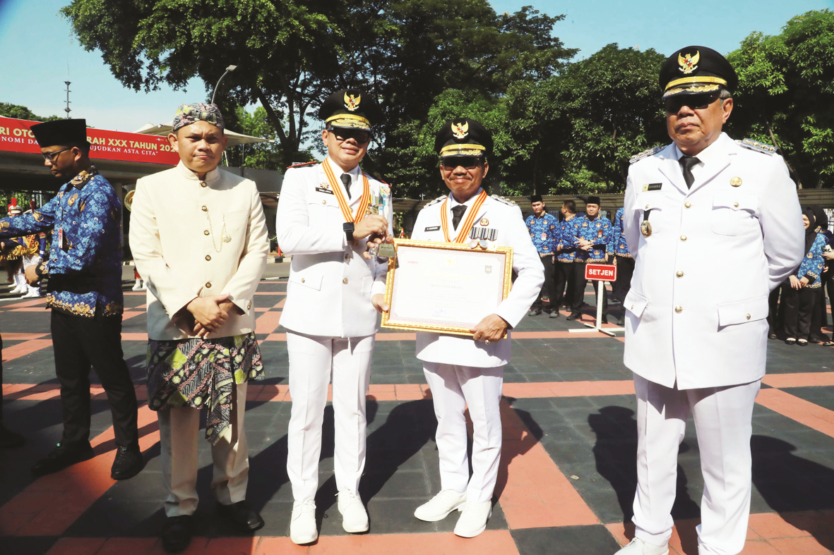 Wali Kota Tangerang, Sachrudin (kedua dari kanan) secara simbolis menerima penghargaan dari Kementerian Dalam Negeri (Kemendagri) Republik Indonesia (RI) usai meraih predikat Penyelenggaraan Pemerintahan Daerah dengan Kinerja Tinggi di peringatan Hari Otonomi Daerah (Otda), Senin (27/4).