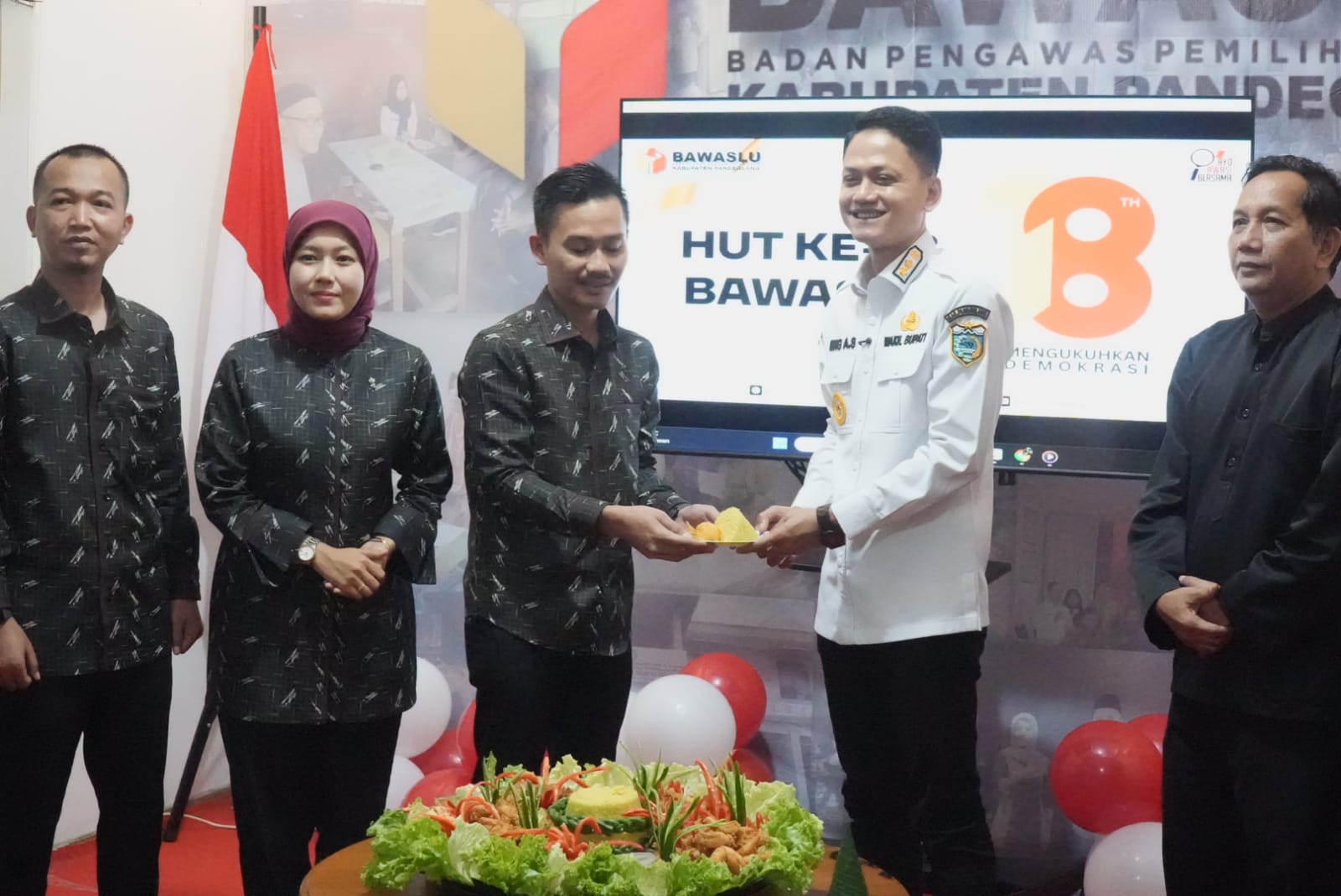 Wabup Pandeglang Iing Andri Supriadi didampingi Asda I Setda Pandeglang, sedang menerima potongan tumpeng dari pihak Bawaslu Pandeglang, saat acara peringatan HUT ke-18 Bawaslu, di Kantor Bawaslu Pandeglang, Kamis (9/4).