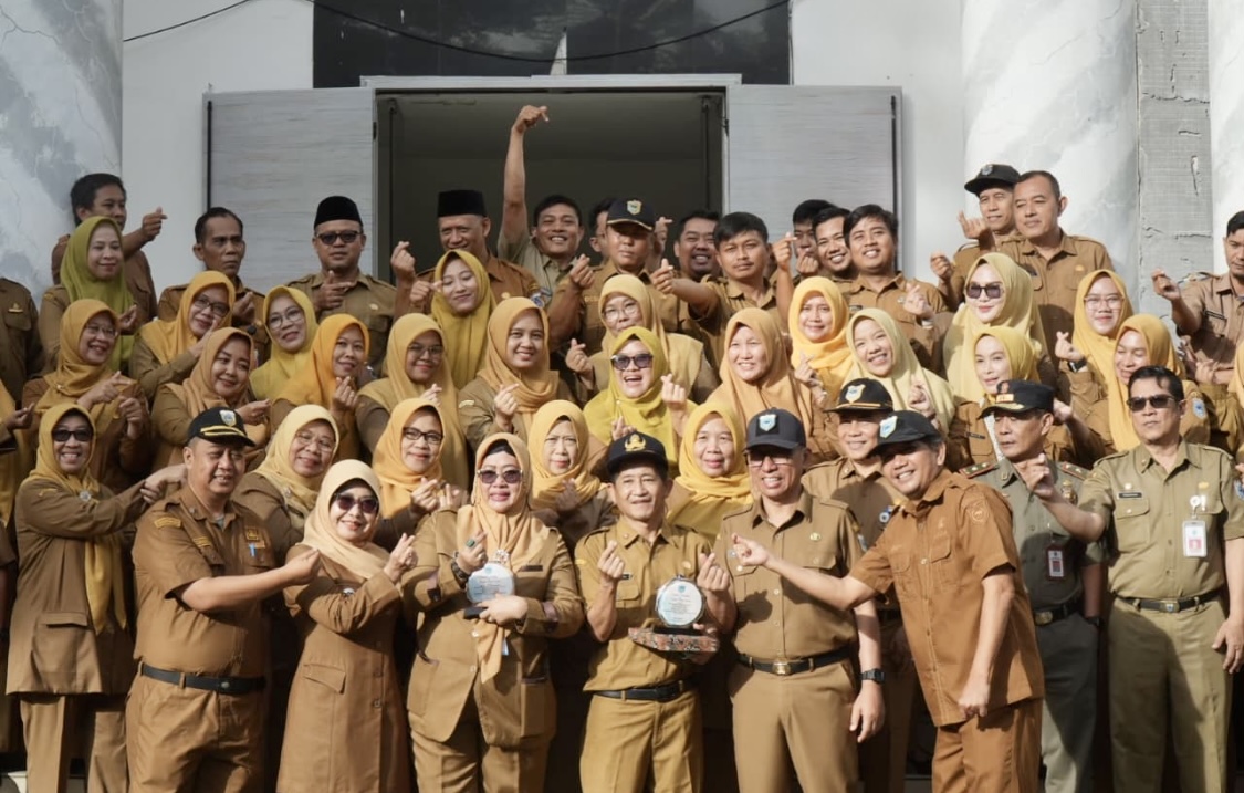 Sekwan dan Asda II Ekbang Setda Pandeglang memegang cinderamata, jelang purna bakti melakukan foto bersama bareng Bupati Pandeglang, Sekda, para Kepala Dinas dan pegawai lainnya di lingkungan Pemkab Pandeglang, usai apel dan ramah tamah perpisahan, di Lingkungan Kantor Setda Pandeglang, Senin (25/5). (ISTIMEWA)