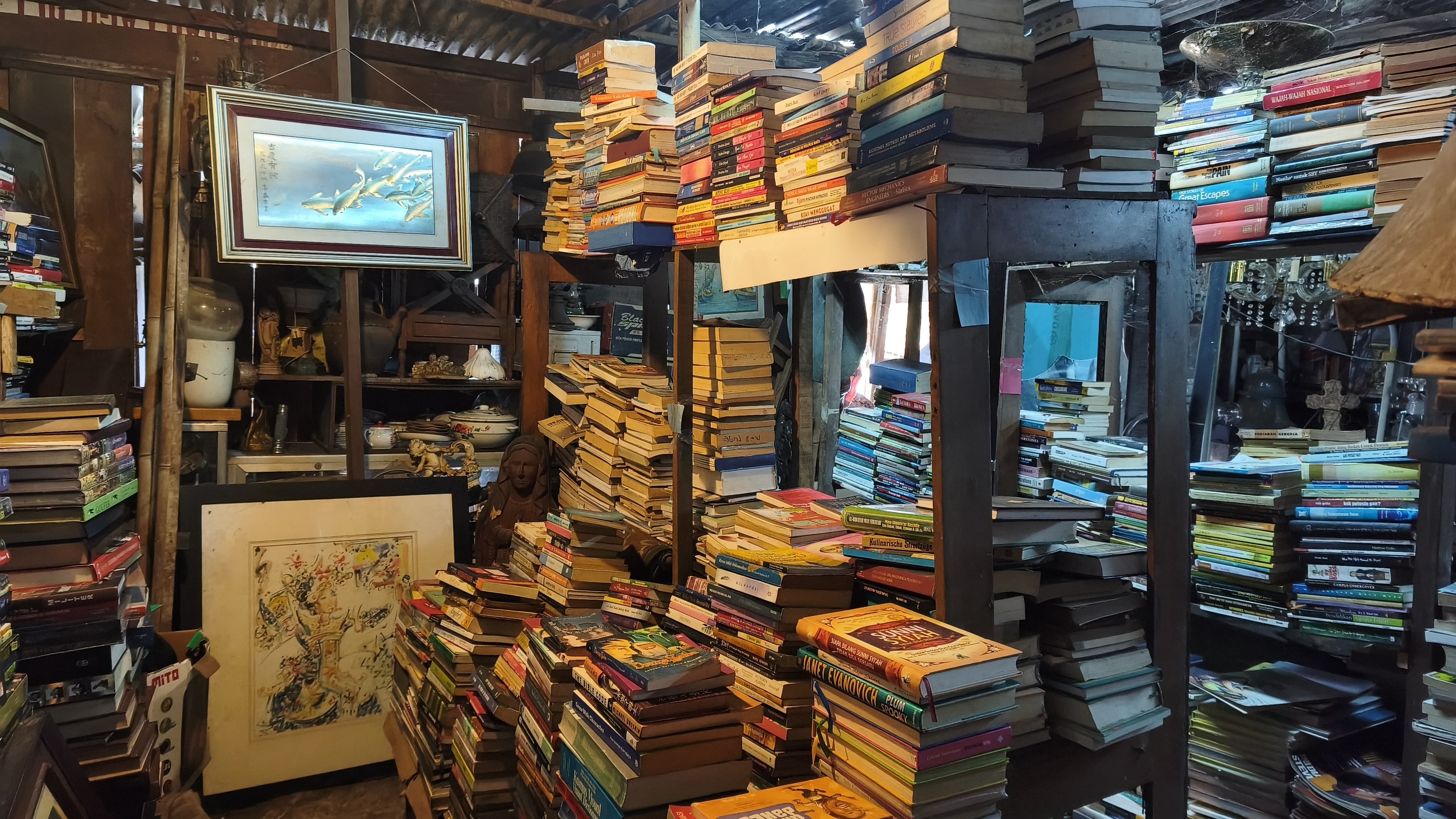 Deretan buku-buku lawas tertata memenuhi sudut ruangan Jhon Book Store N Art di kawasan Pamulang, Tangerang Selatan. Nuansa klasik berpadu dengan aroma kertas lama menghadirkan daya tarik tersendiri bagi pecinta literasi, pemburu buku bekas, hingga kolektor buku langka yang ingin menelusuri jejak cerita dari masa ke masa. Foto : Emir MG